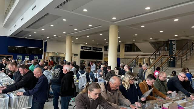 Crowd browsing through vinyl records at the York Record Fair, with stalls and shoppers in a spacious venue.