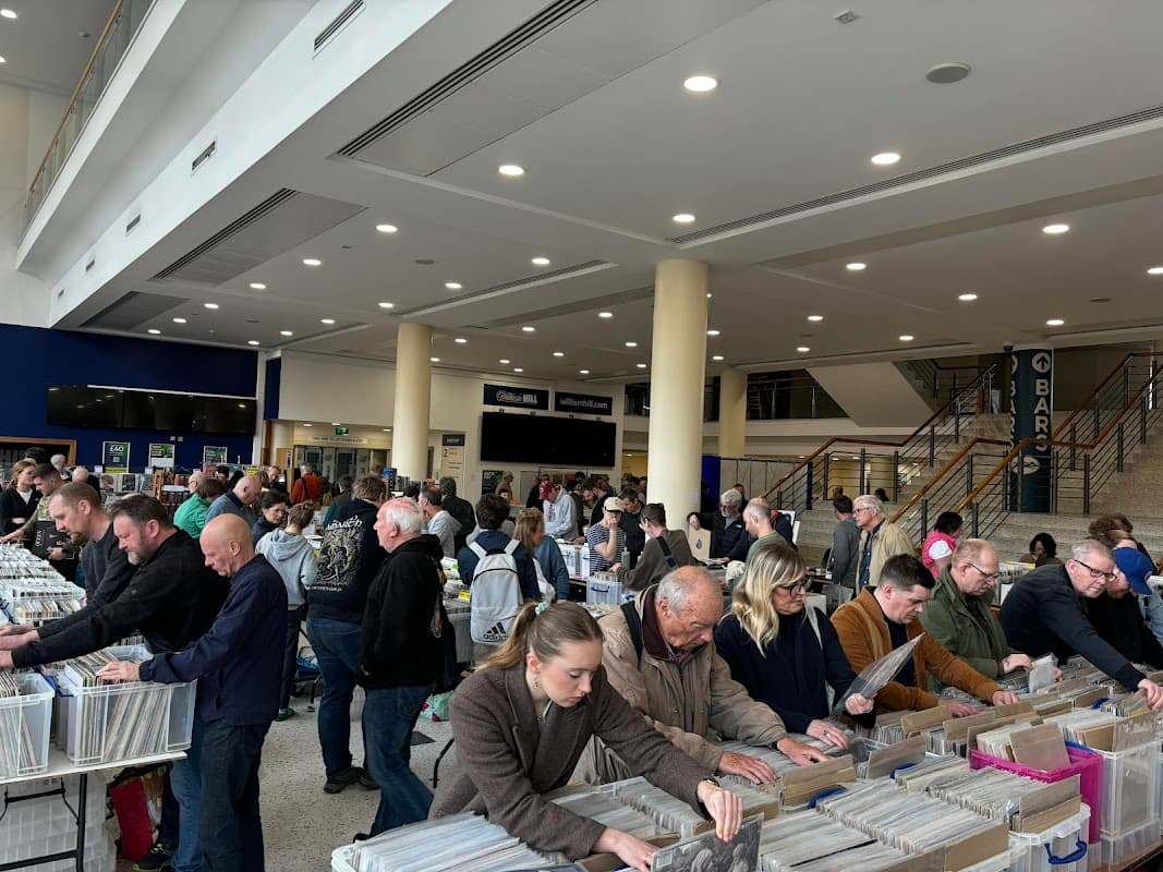 Crowd browsing through vinyl records at the York Record Fair, with stalls and shoppers in a spacious venue.