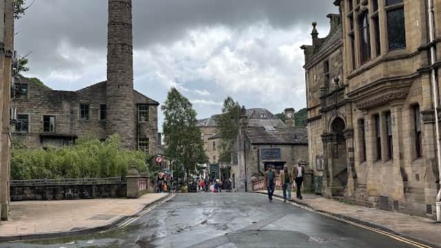 GeniePoint Charging Station in Chiserley, Yorkshire, with historic buildings and a cloudy sky in the background.