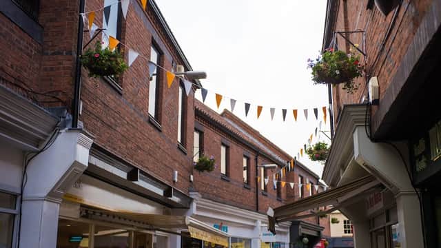 Brick buildings with hanging flower baskets and bunting flags, creating a vibrant shopping atmosphere in Osgodby.