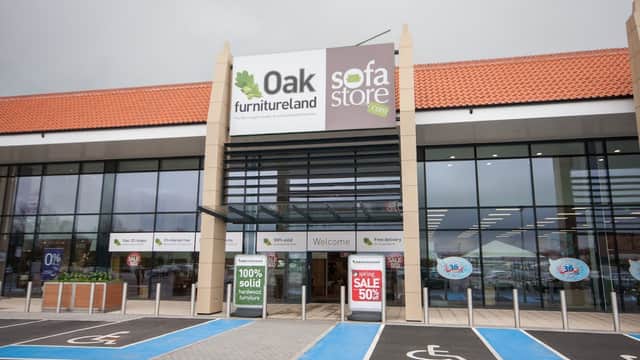 Entrance to Oak Furnitureland with large signage, accessible parking, and promotional sale banners.