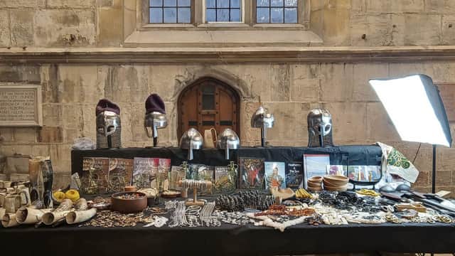 Viking-themed crafts and jewelry displayed on a table, featuring helmets, pottery, and decorative items in a historic setting.