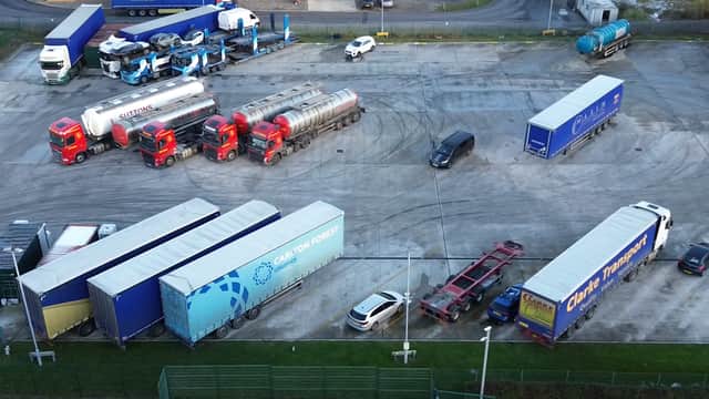 Aerial view of Onward Lorry Park with parked trucks, trailers, and a few cars on a large gravel lot.