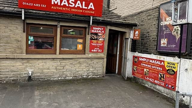 Bright red signage for "Simply Masala" restaurant, featuring windows and a door, with nearby pharmacy signage.