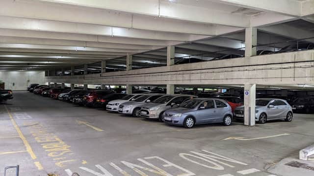 Multi-level car park with parked vehicles, concrete structure, and clear signage indicating "No Entry."