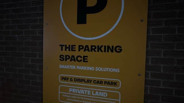 Bright yellow sign with a large "P" indicating a pay and display car park, labeled as private land.
