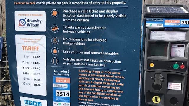 Welcome sign for Thomas Street Car Park with parking tariff details and a pay station in Exley, Yorkshire.