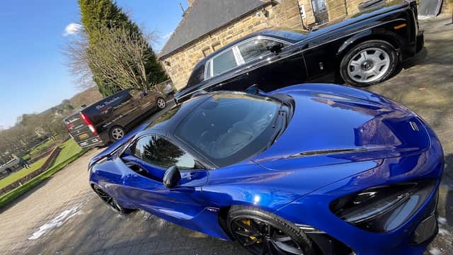 Luxury cars parked in a scenic area with stone buildings and greenery in Bradfield, Yorkshire.