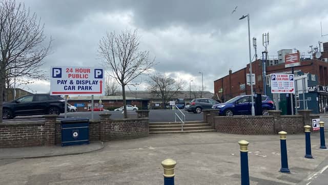 24-hour public pay and display car park with signs, parked cars, and cloudy sky in Filey, Yorkshire.