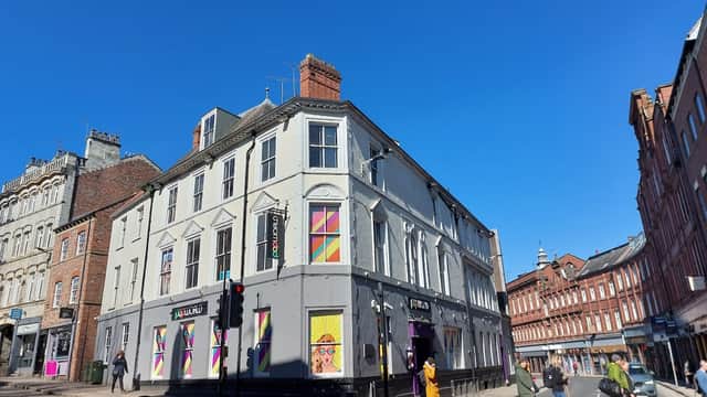 Colorful exterior of Popworld York nightclub, with vibrant window designs and a clear blue sky overhead.